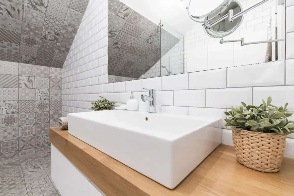 Une salle de bain moderne avec un lavabo rectangulaire blanc, des carreaux muraux blancs et des carreaux décoratifs gris. Une excellente idée carrelage petite salle de bain pour un look chic.