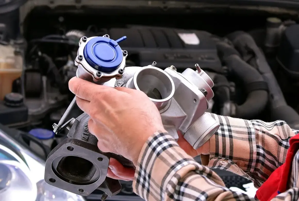 Mechanik pokazuje turbosprężarkę, element kluczowy dla czujnika ciśnienia doładowania. Gdzie się znajduje? W silniku!
