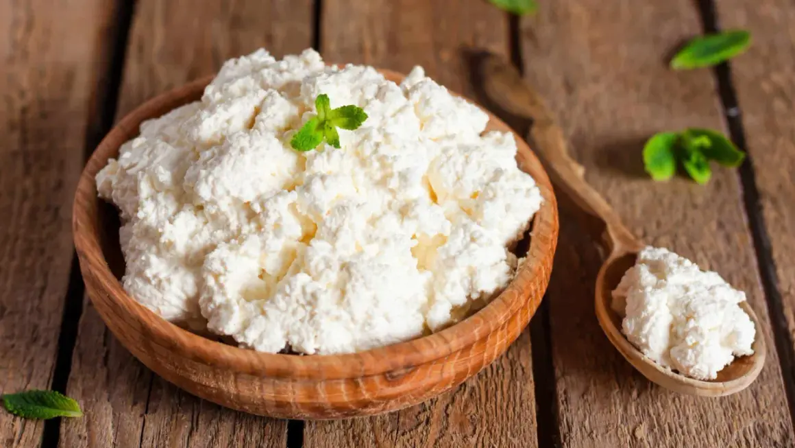 Fiocchi di latte in una ciotola di legno, guarniti con menta. Attenzione, i fiocchi di latte fanno ingrassare se consumati in eccesso!