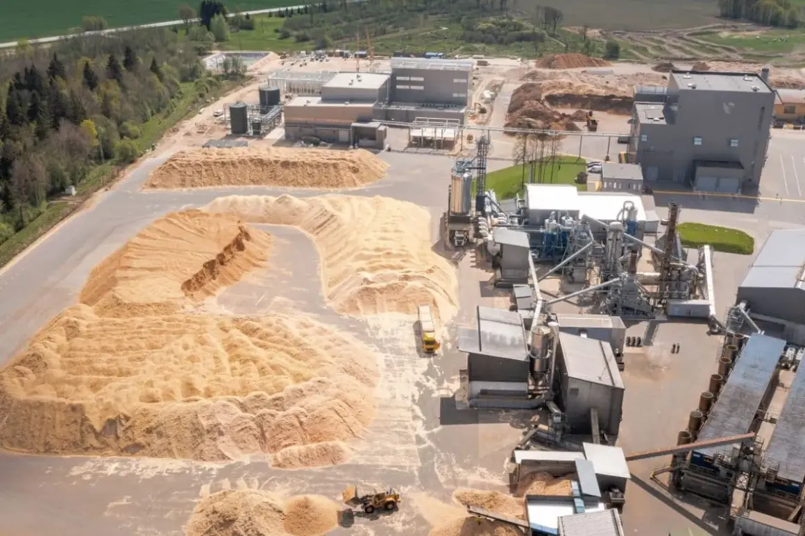 Vue aérienne d'une usine de transformation du bois avec d'énormes tas de sciure. Le prix de la sciure de bois à la tonne est un facteur clé pour cette industrie.