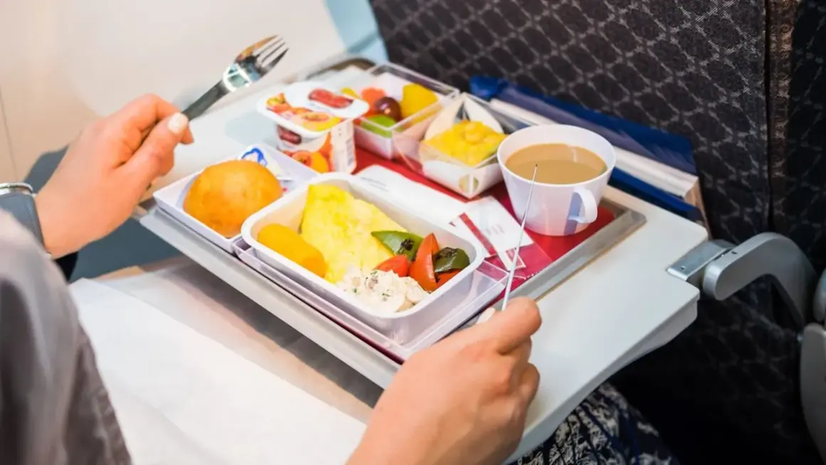 Un pasto aereo con omelette, verdure, pane e caffè. Si può portare cibo in aereo, e questo è un esempio di come viene servito.