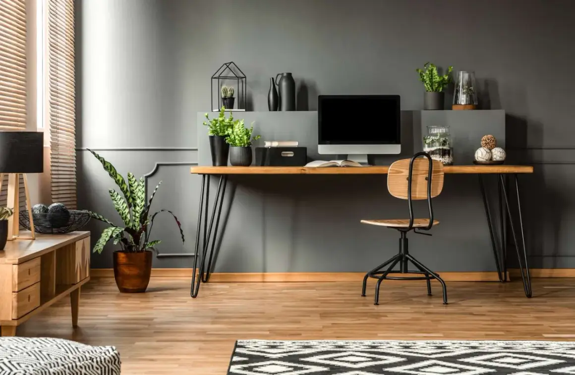 A modern desk setup with a computer, plants, and decorative items. This image shows how to hide cords on desk for a clean, organized workspace.