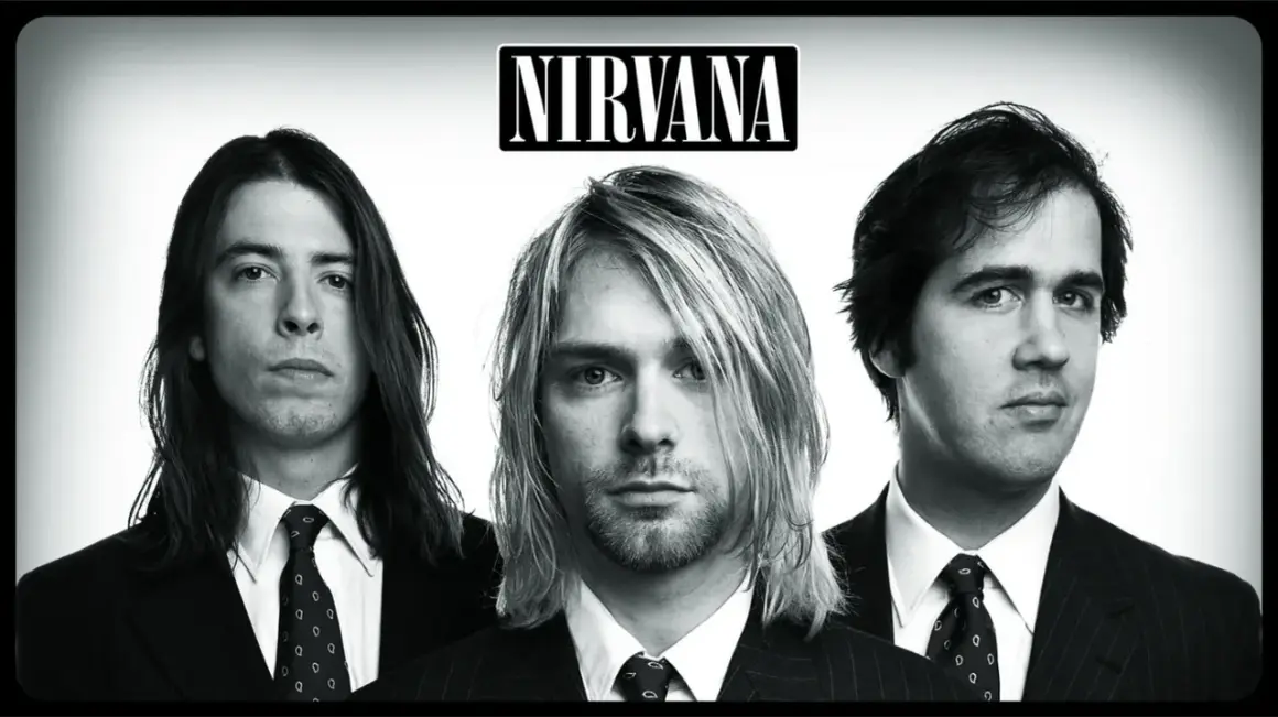 Trzech członków zespołu Nirvana w garniturach: Kurt Cobain, Dave Grohl i Krist Novoselic.