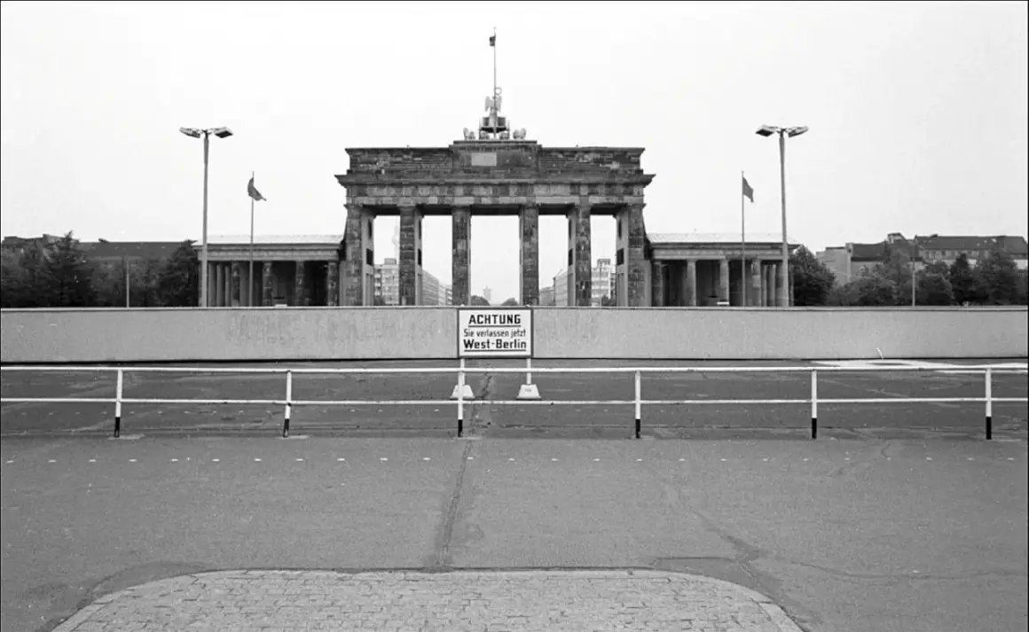 Brama Brandenburska za murem, kiedy zbudowano mur berliński. Znak ostrzega: "Uwaga, opuszczasz teraz Berlin Zachodni".