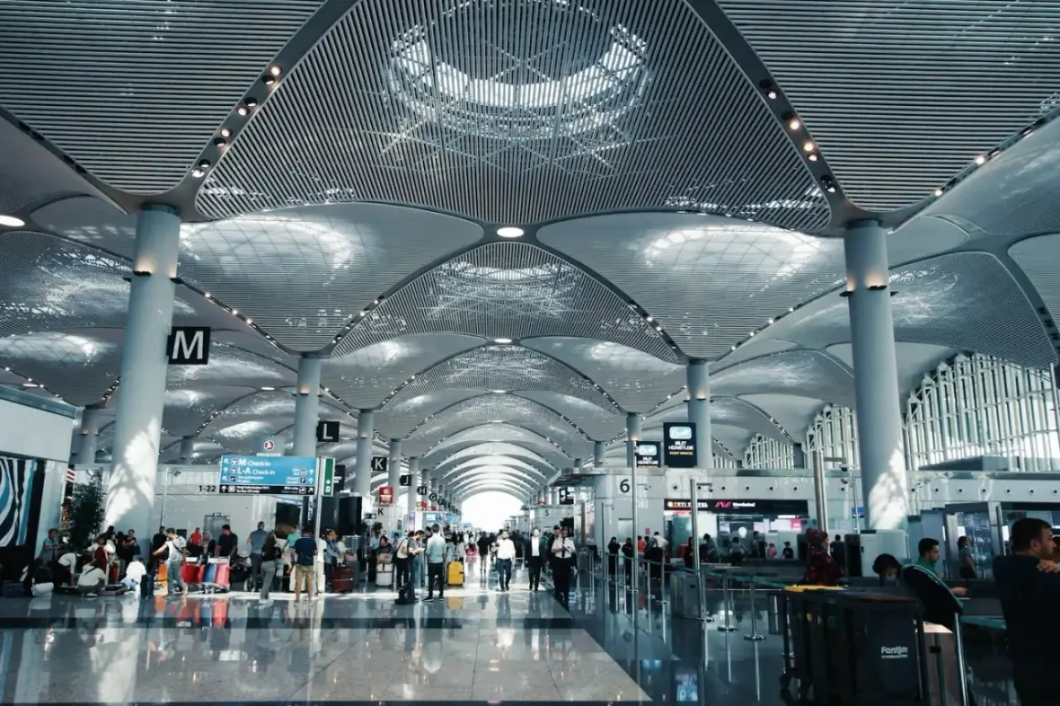 Nowoczesny terminal lotniska z ludźmi i bagażami. Zastanawiasz się, ile wcześnie być na lotnisku? Tutaj jest tłoczno.