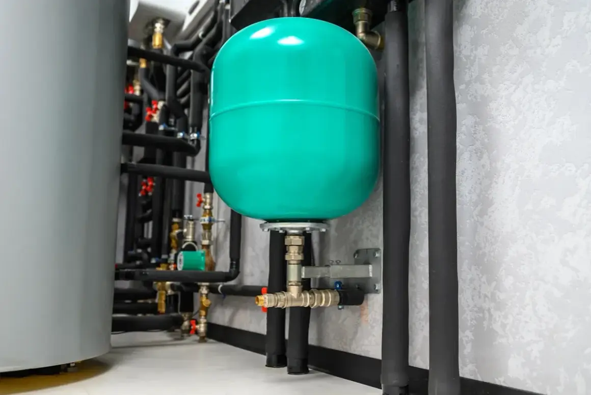 Réservoir d'expansion vert vif, partie d'un système de plomberie avec une pompe booster.