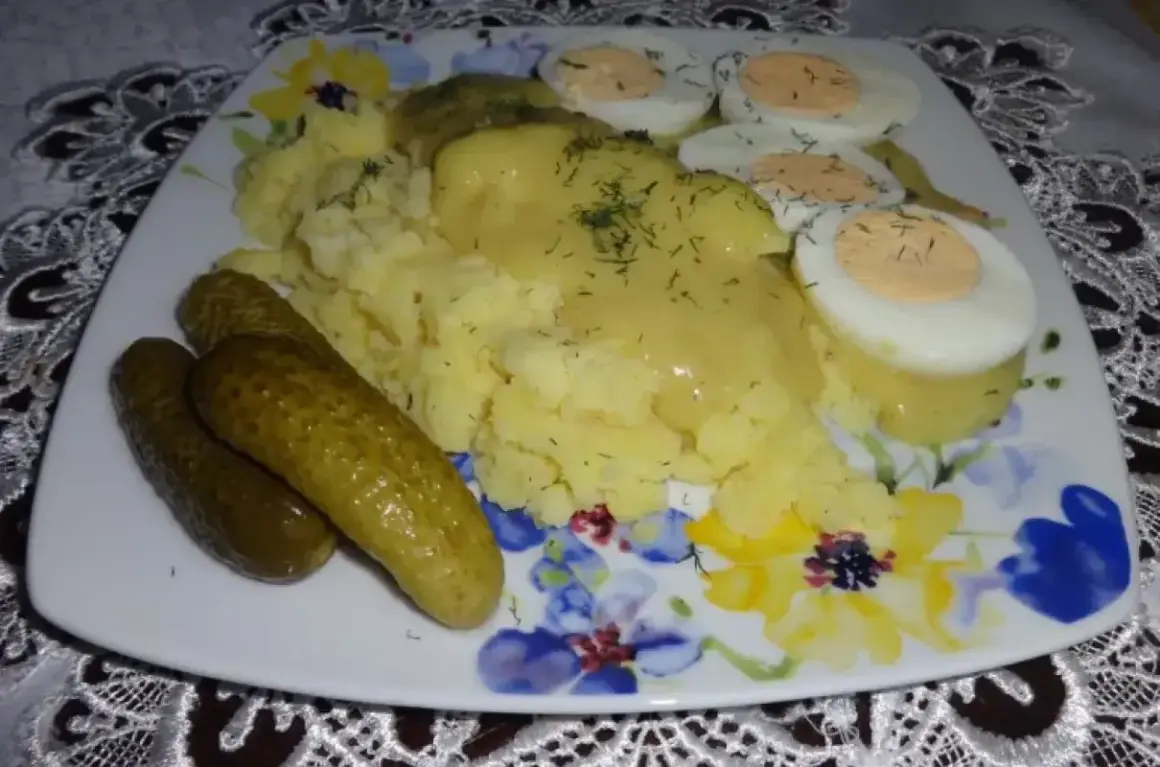 Talerz z ziemniakami puree, jajkami na twardo i ogórkami kiszonymi, polany sosem musztardowym.
