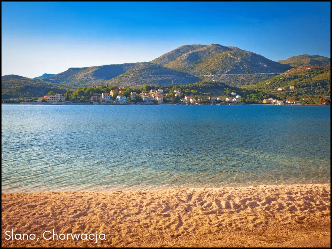 Słoneczna plaża i spokojne morze w Słano, Chorwacja. W oddali widać urokliwe **małe wyspy chorwackie** i zielone wzgórza.