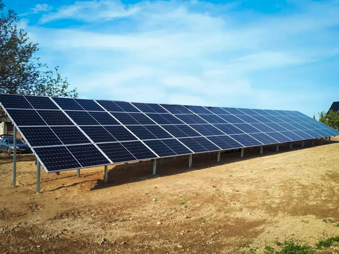 Długa instalacja fotowoltaiczna na stelażach, gotowa do zbierania energii słonecznej.