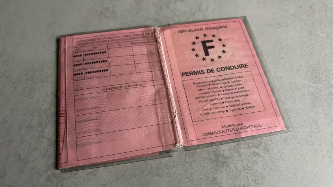 Un ancien permis de conduire français, rose, ouvert, montrant les catégories de véhicules et les mentions.