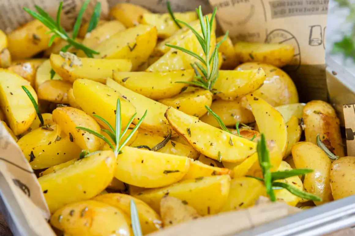 Goldgelbe rosmarinkartoffeln vom blech, knusprig und aromatisch, mit frischen Rosmarinzweigen garniert. Ein Genuss für Augen und Gaumen.