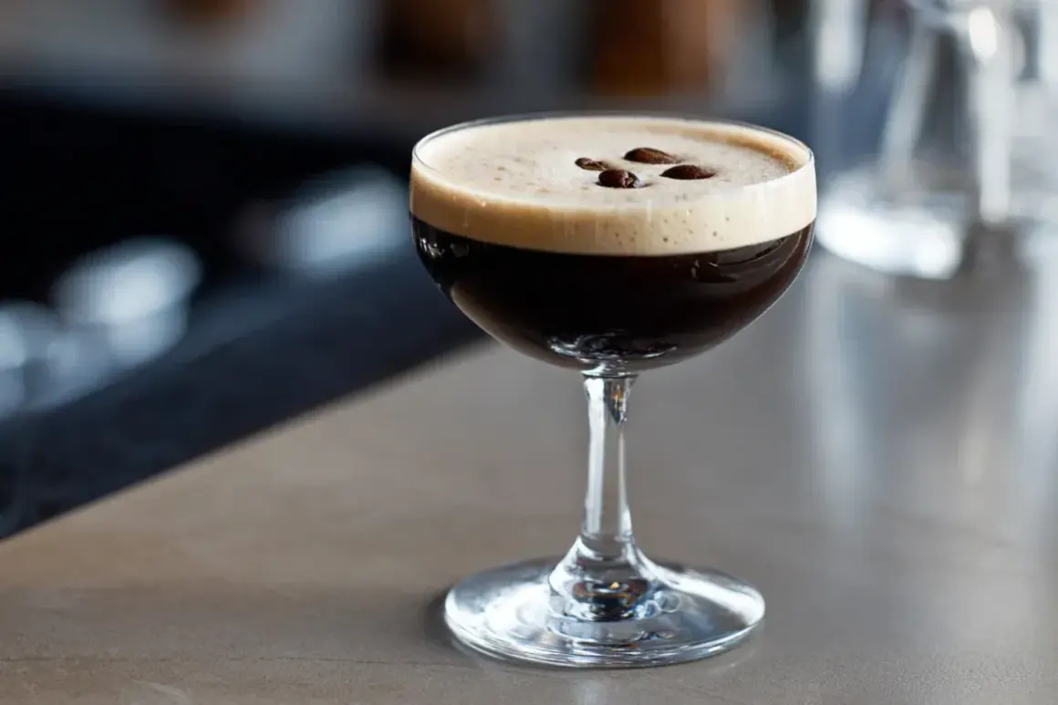 En perfekt espresso martini med krämig skum och tre kaffebönor som dekoration.