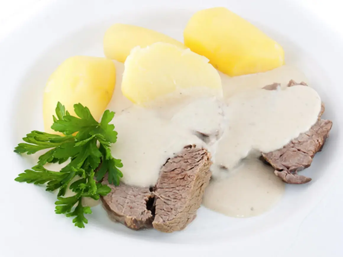 Zartes Krenfleisch mit Salzkartoffeln und cremiger Soße, ein Klassiker aus Bayreuth, garniert mit Petersilie.