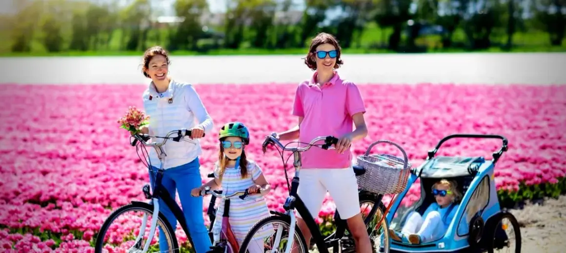 Familia disfrutando de un paseo en bici por campos de tulipanes rosas en Holanda.
