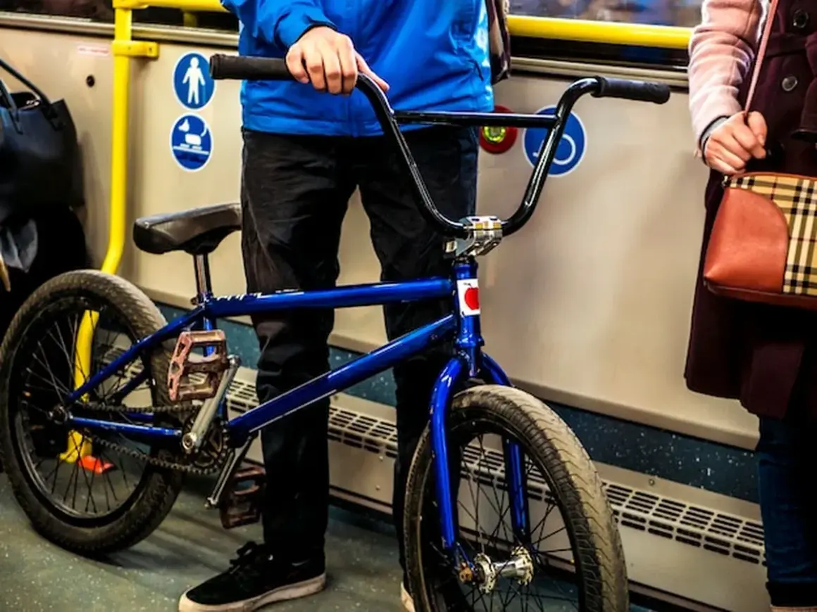 Chłopak z niebieskim rowerem BMX w autobusie, gotowy do podróży.