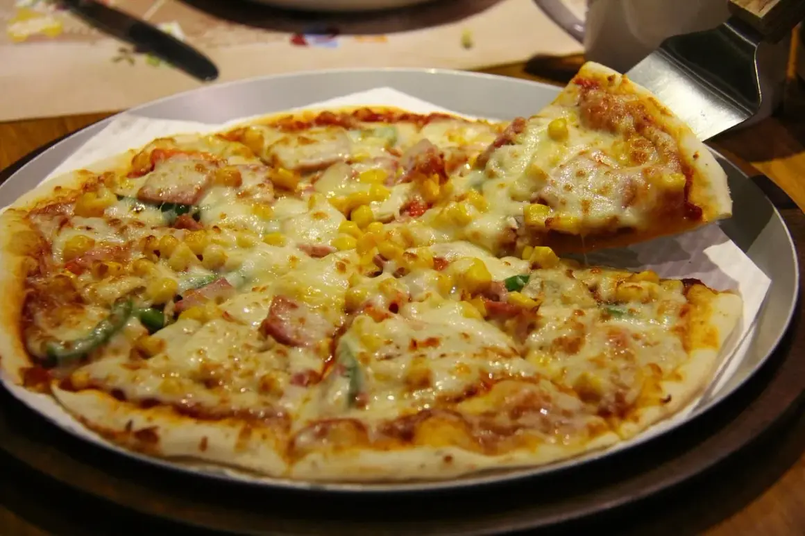 Pyszna hawajska pizza z ananasem, szynką i kukurydzą, właśnie podana.