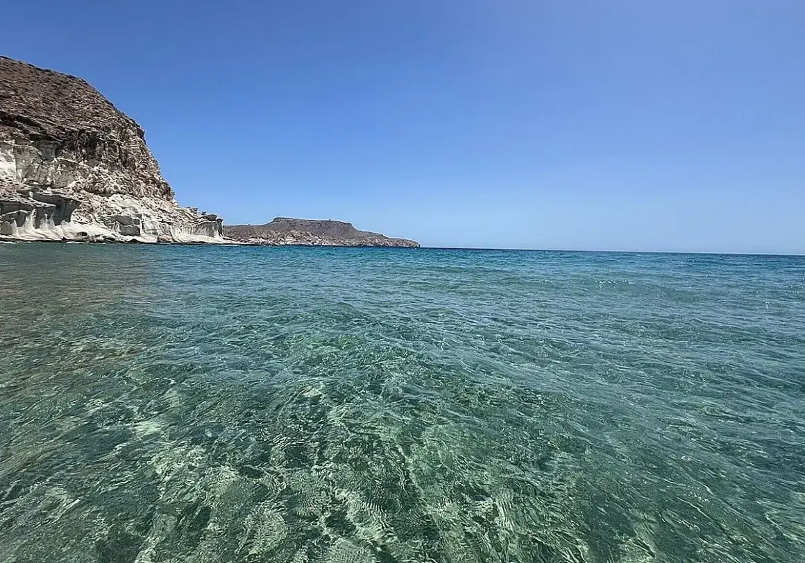 Aguas cristalinas y acantilados blancos en las piscinas naturales de Cabo de Gata. El mar turquesa invita a explorar este paraíso.