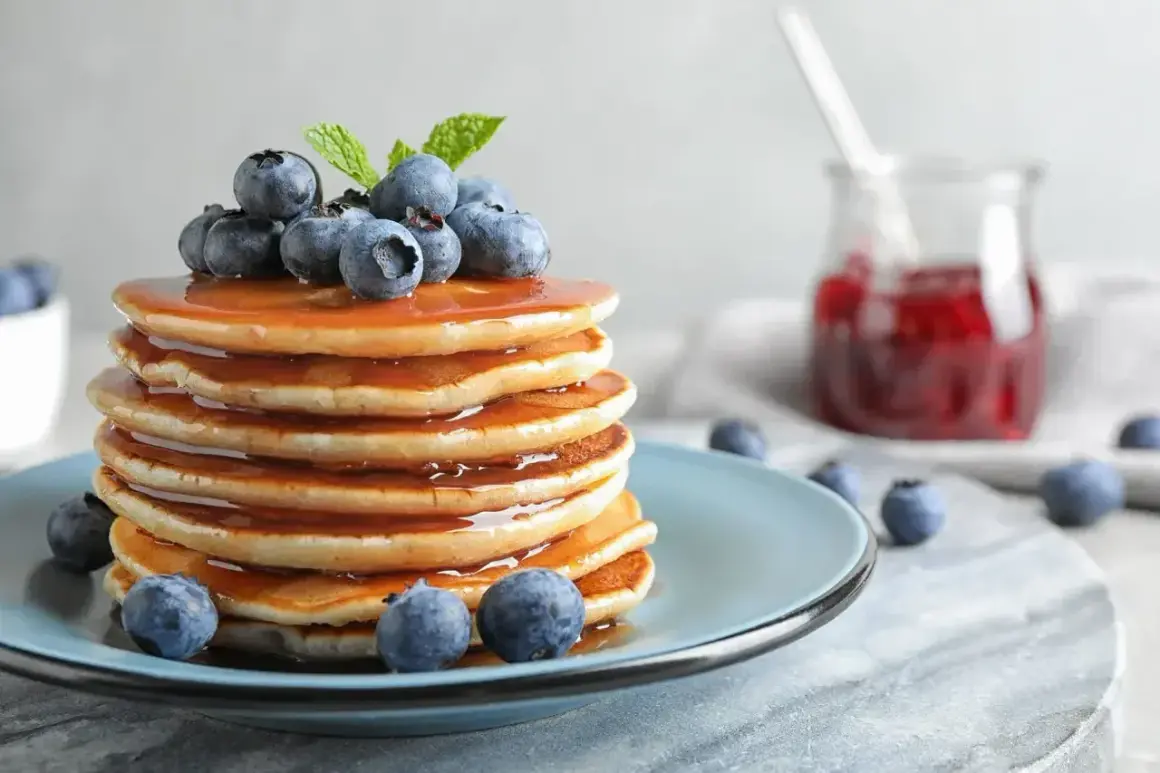 Pyszny stosik naleśników z syropem, borówkami i miętą. Idealny przepis na pancake na słodkie śniadanie.