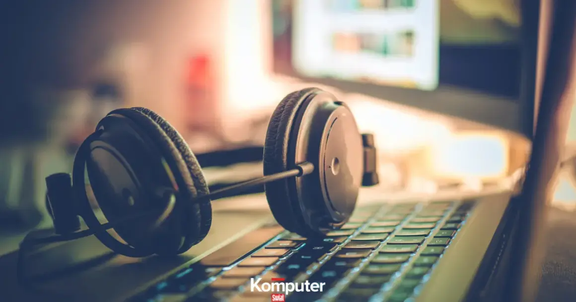 Słuchawki na klawiaturze laptopa, gotowe do zanurzenia się w muzyce na komputerze.