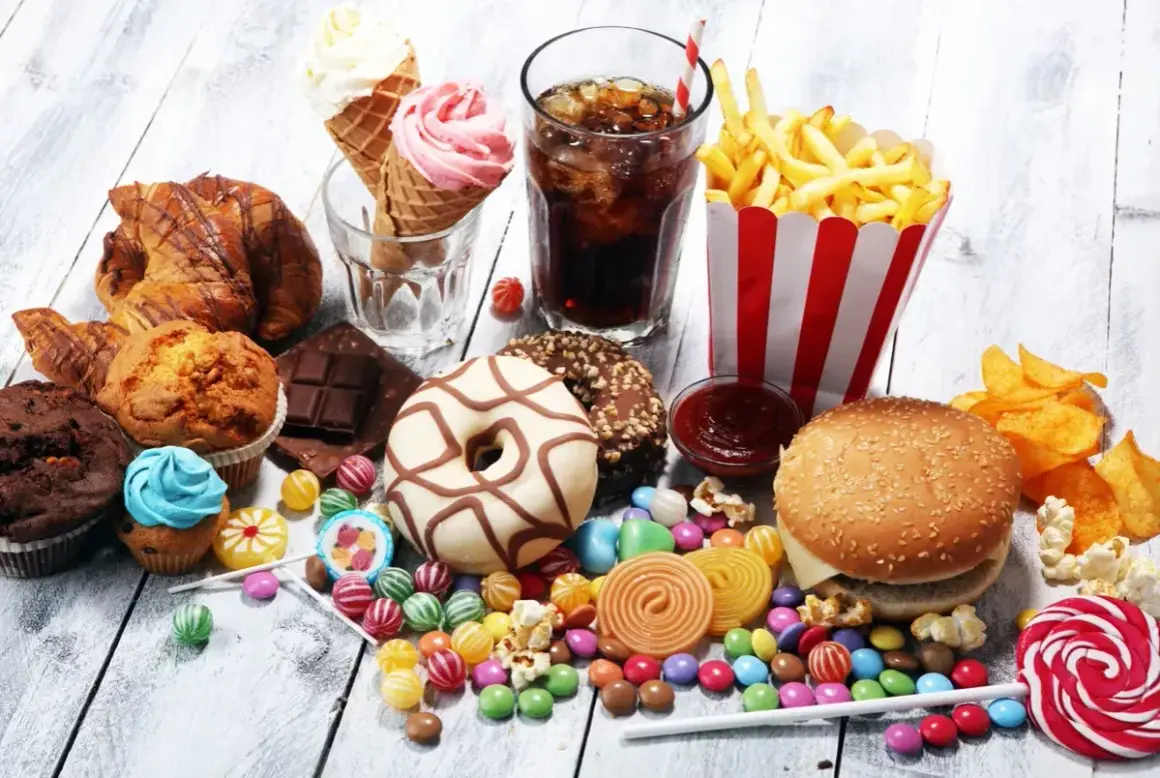 En överflöd av ultraprocessad mat: hamburgare, pommes frites, donuts, godis, glass, läsk och bakverk.