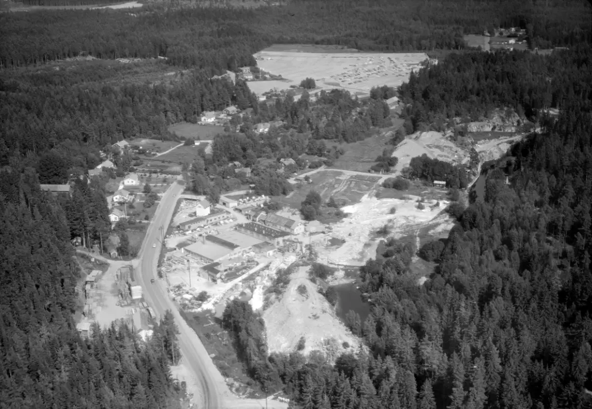 Överblicksbild över marmorbruket Kolmården med byggnader, stenbrott och skog.