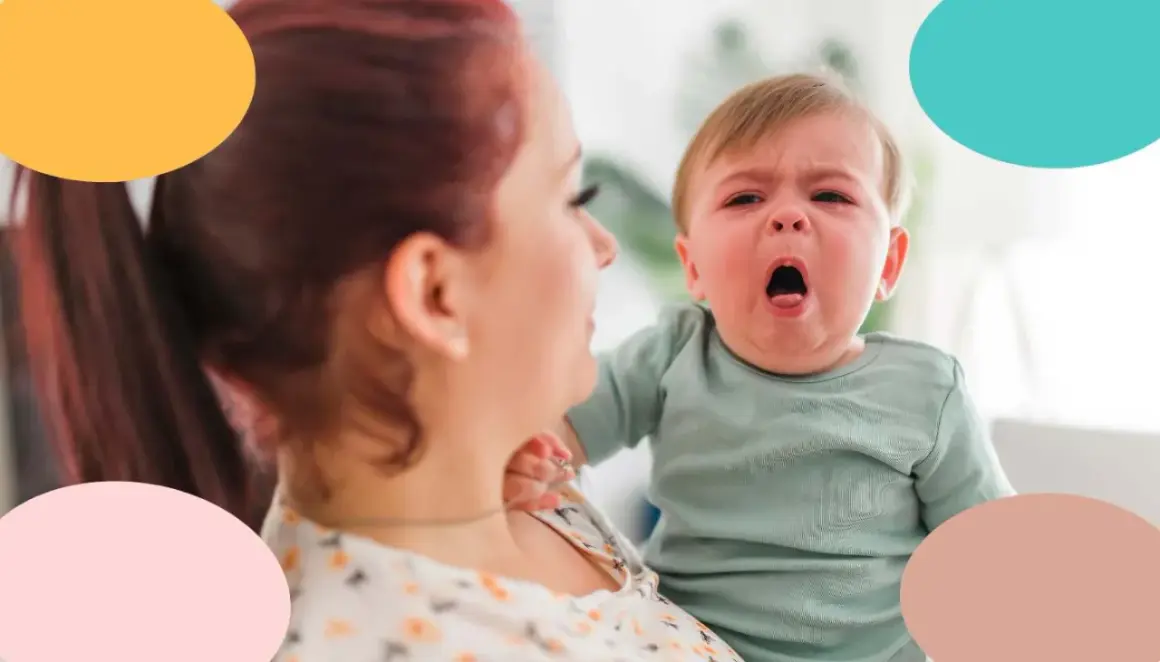 Bebé con tos, llorando en brazos de su madre.