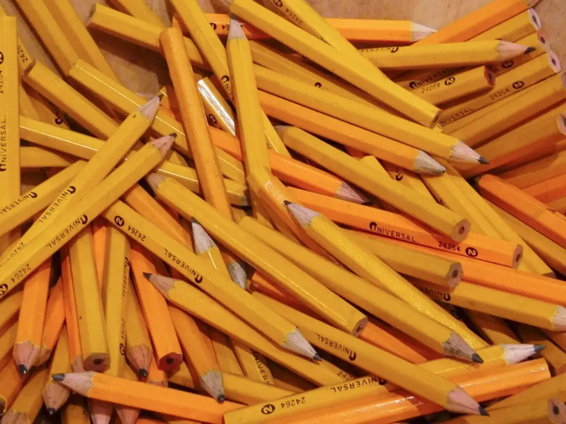 A pile of yellow pencils, a classic choice for a reason. Why are pencils yellow? It's a tradition dating back to the 1800s.