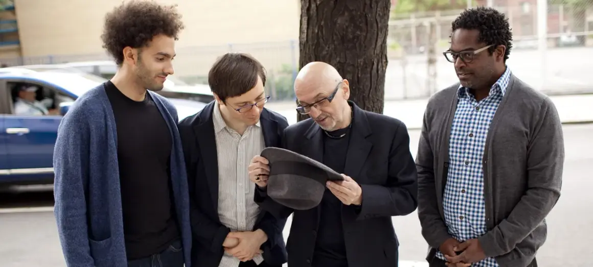 Tomasz Trebacz i kompozytor jazzowy, z kolegami, dyskutują o kapeluszu.