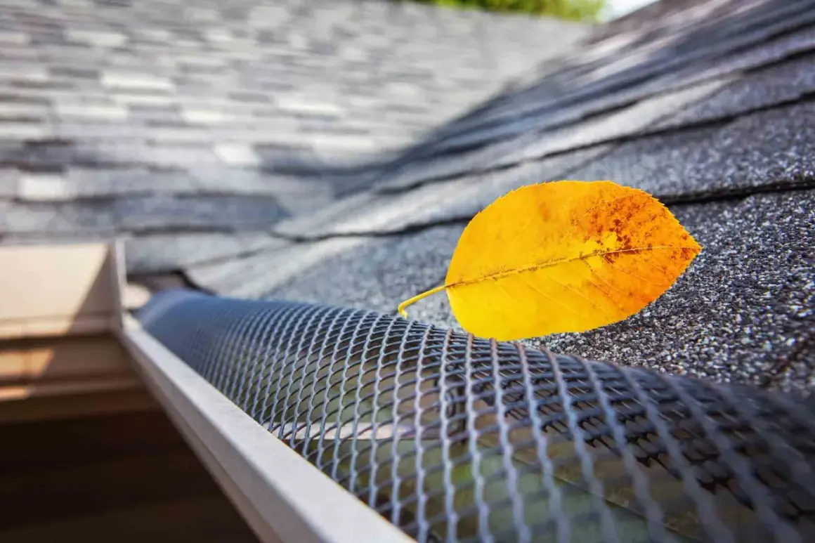 A yellow leaf rests on a newly installed gutter guard, showcasing its effectiveness against falling debris.