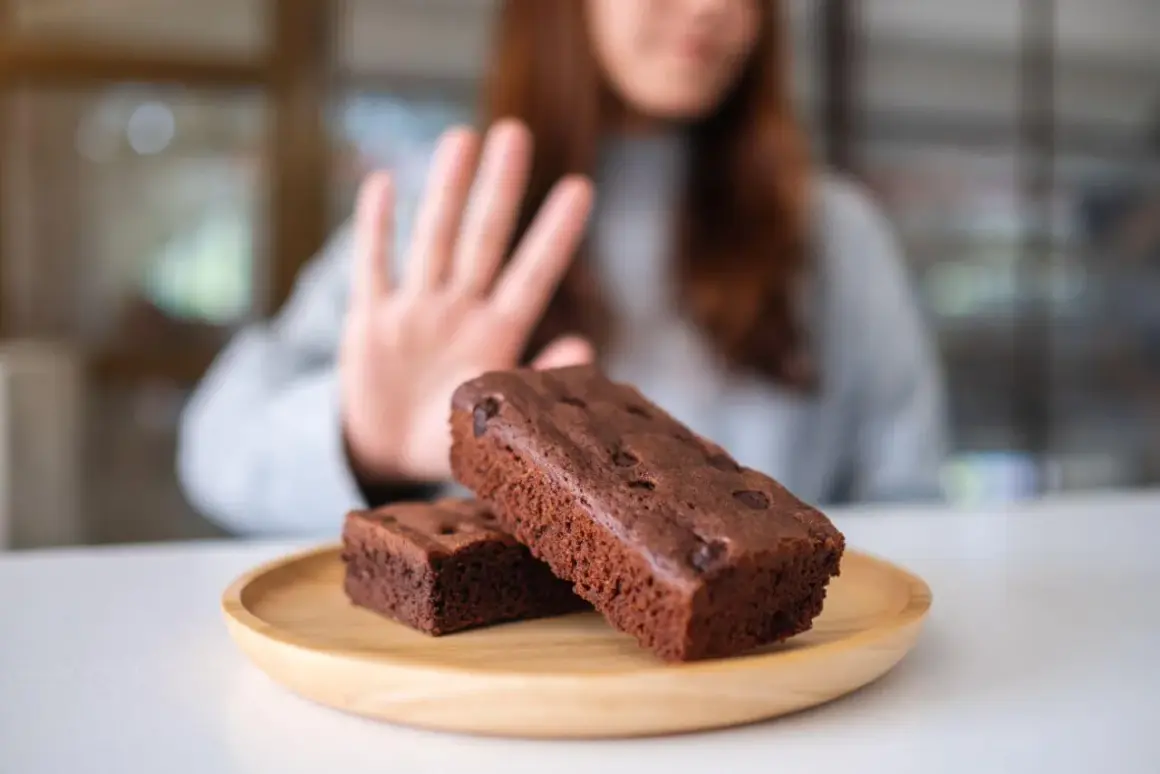 Kobieta odrzuca brownie, wybierając dietę bez cukru.