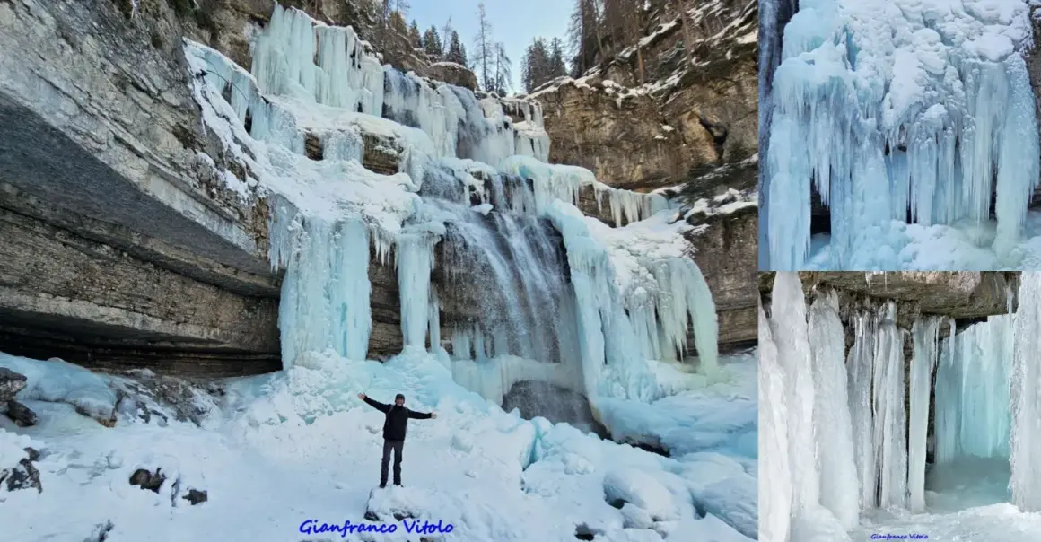 Un uomo in piedi sulla neve ammira le spettacolari cascate vallesinella ghiacciate, con stalattiti di ghiaccio che scendono dalle rocce.