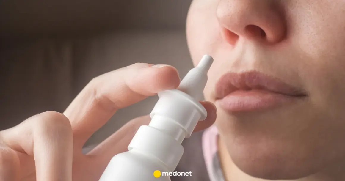 Dłoń trzymająca atomizer leku Avamys, gotowa do aplikacji do nosa.