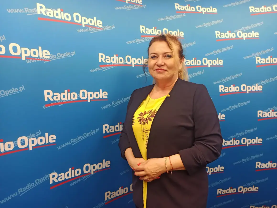 Kobieta w żółtej bluzce i granatowej marynarce na tle z logo Radia Opole.