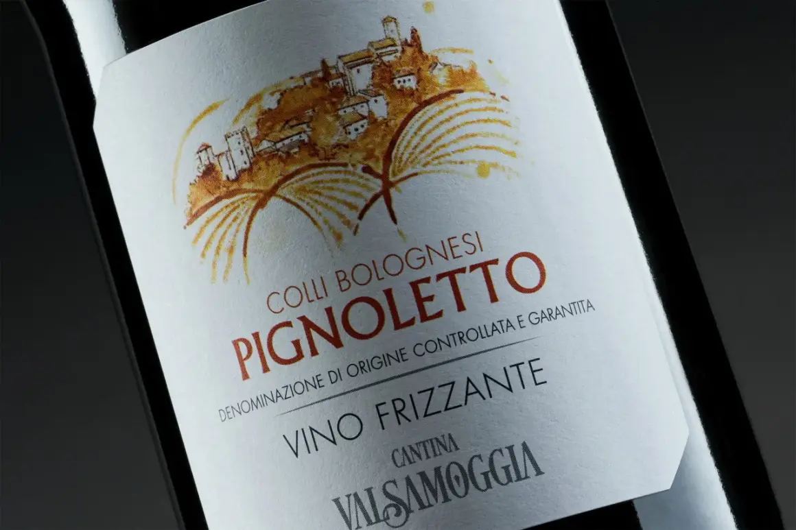 Etichetta di Pignoletto Frizzante, vino tipico bolognese, con disegno di un borgo collinare e vigneti.