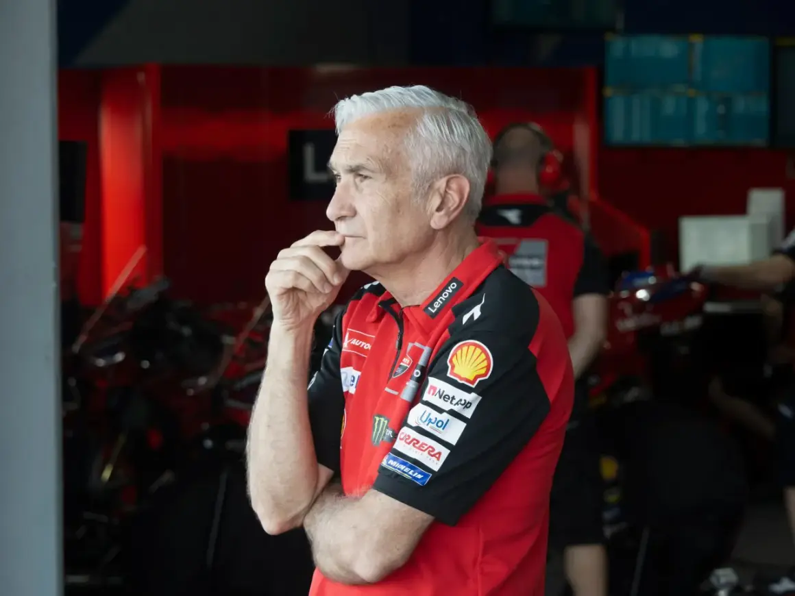 Davide Tardozzi, con su mano en la barbilla, reflexiona en el box de Ducati.