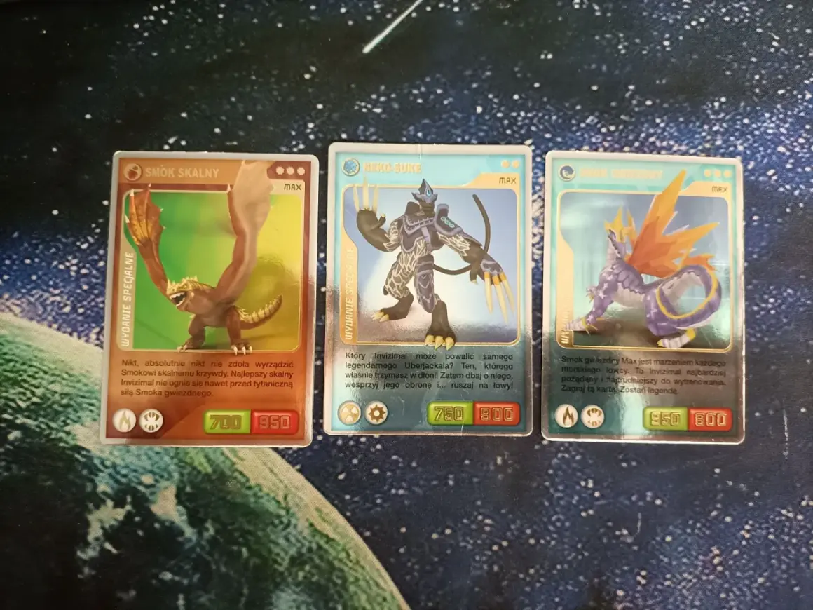 Karty Invizimals: Smok Skalny (700/950), Neko-Suke (750/900), Smok Gwiezdny (950/800).