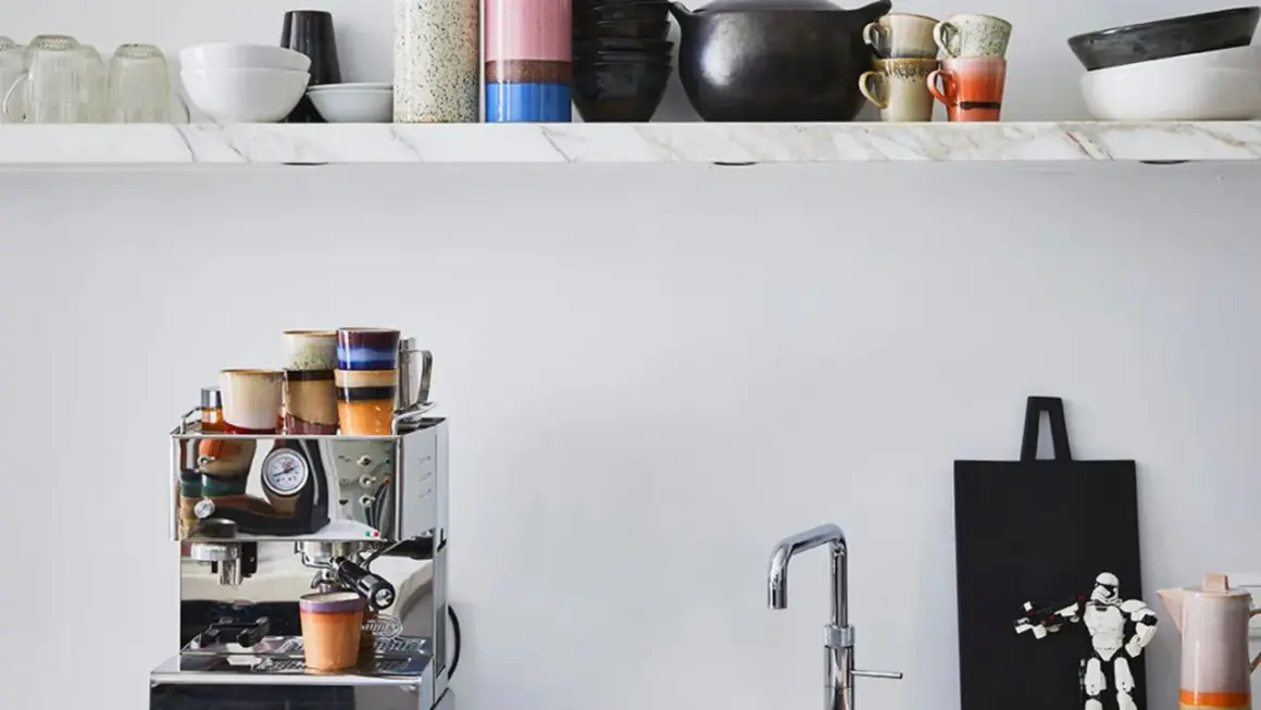 Stilvolle Kaffeebar Ideen: Chrom-Espressomaschine mit bunten Tassen, Marmorregal mit Geschirr und ein Stormtrooper-Dekor.