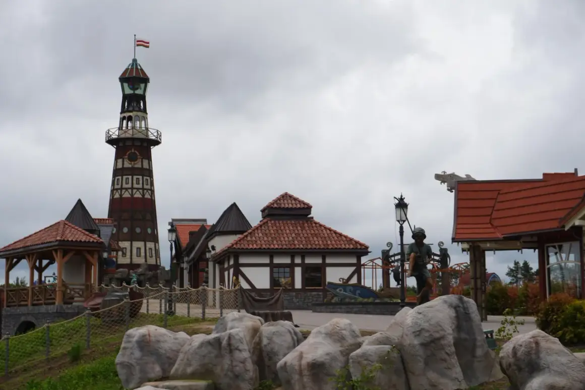 Wesołe miasteczko Hossoland kiedy otwarcie? Widok na latarnię morską, domki w stylu portowym i rzeźby.