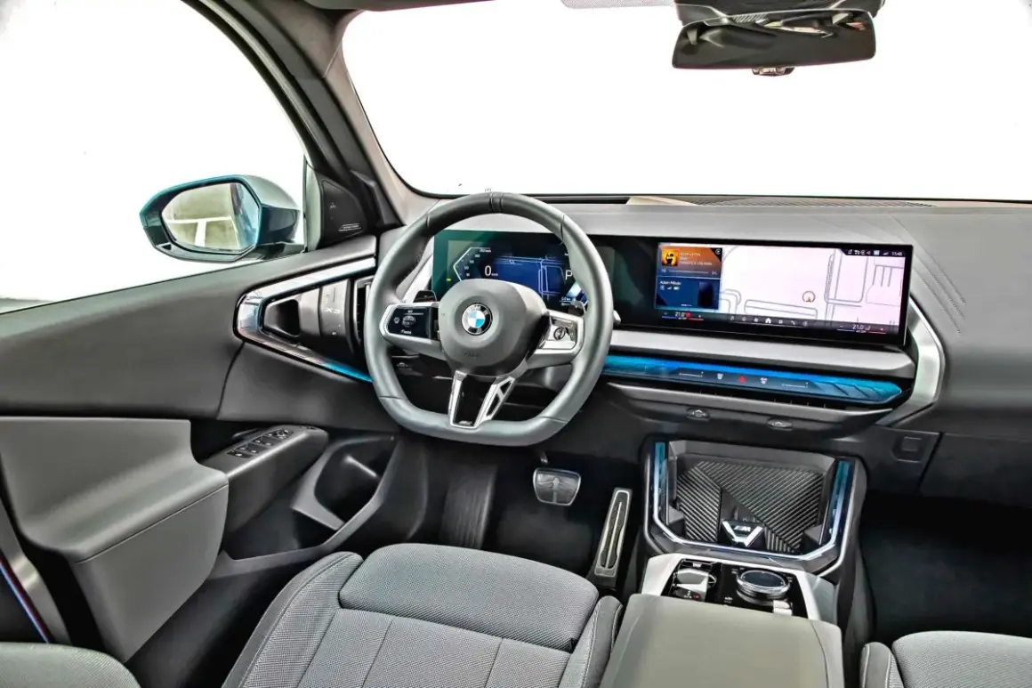 Wnętrze nowoczesnego x3 bmw z dużym ekranem nawigacji i cyfrowymi zegarami.