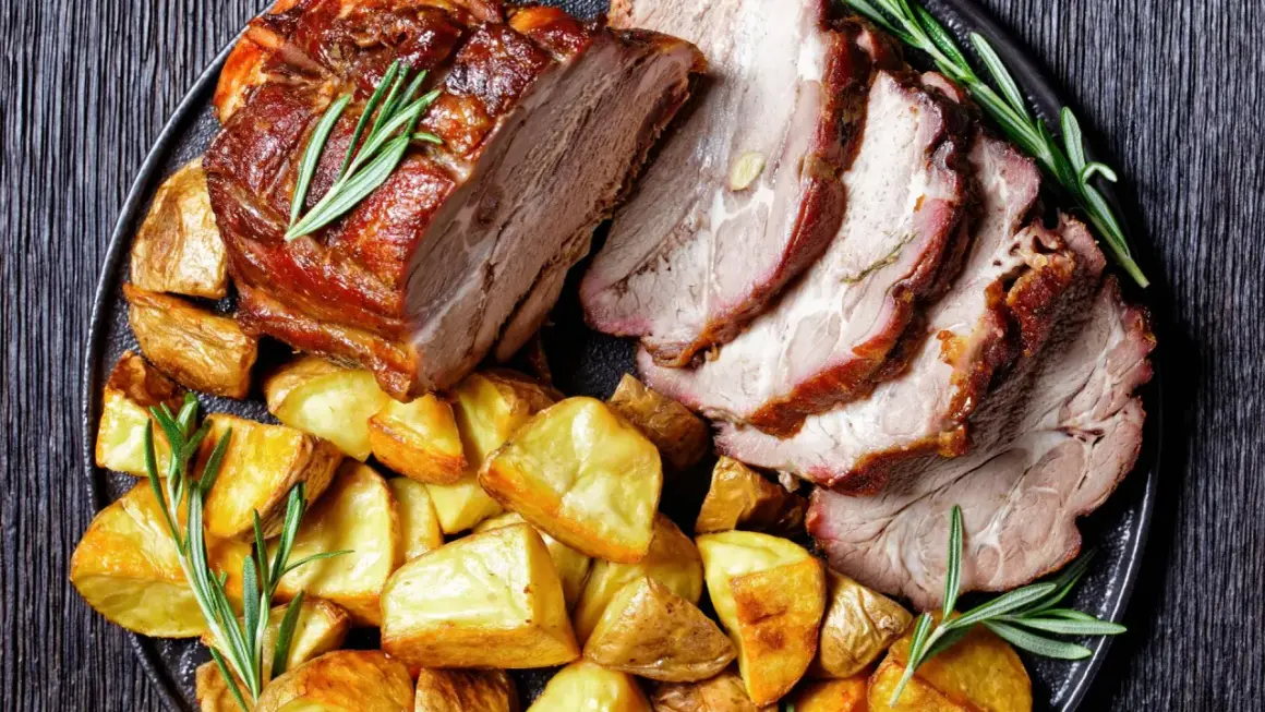 Fettine di maiale al forno morbide, succulente e dorate, servite con patate arrosto e rosmarino fresco.