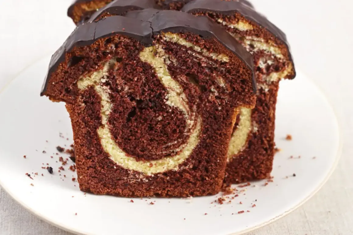 Zwei saftige Scheiben Marmorkuchen mit Schokoladenglasur, perfekt für ein schnelles Marmorkuchen Rezept.
