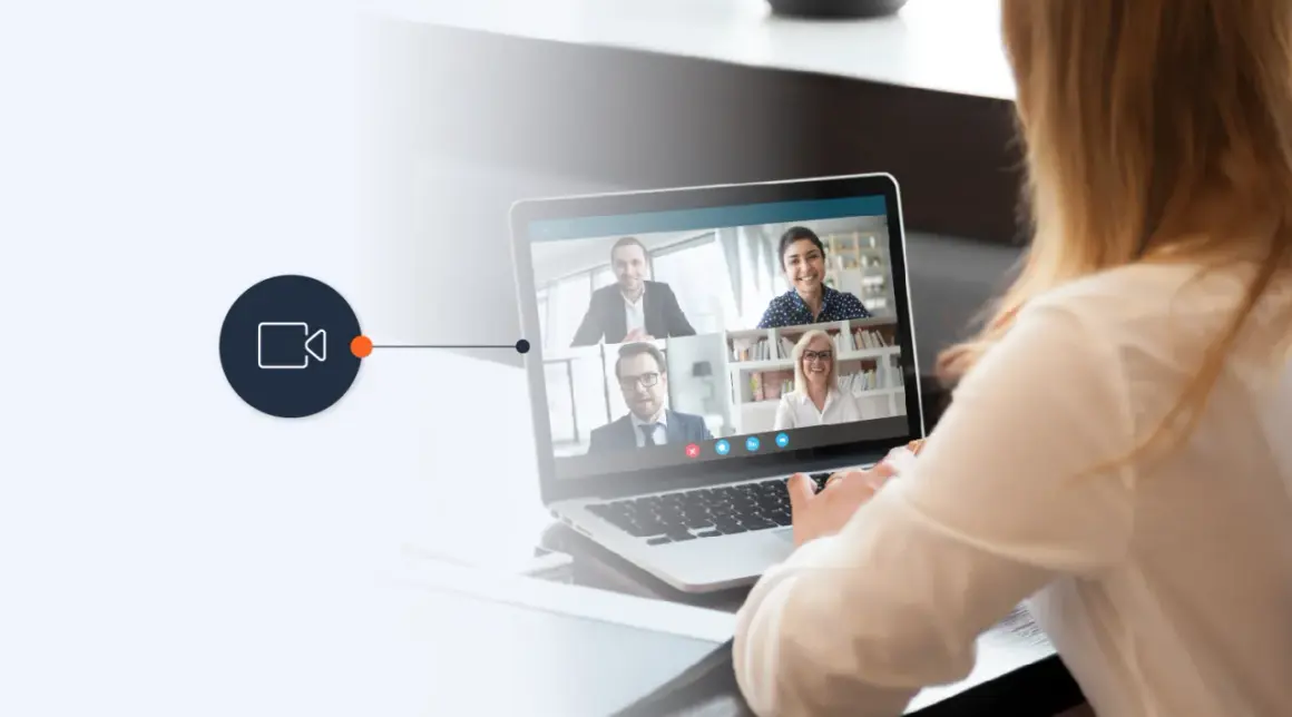 A woman uses a laptop for a video conference, connecting with colleagues via a WebRTC phone call.