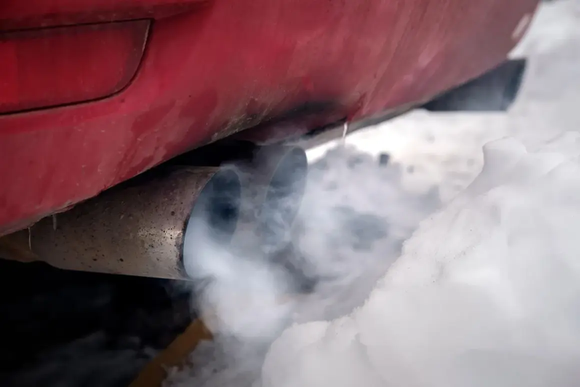 Roter Auspuff mit Rauch im Schnee. Der Motor läuft, um das Auto im Winter warm zu halten.