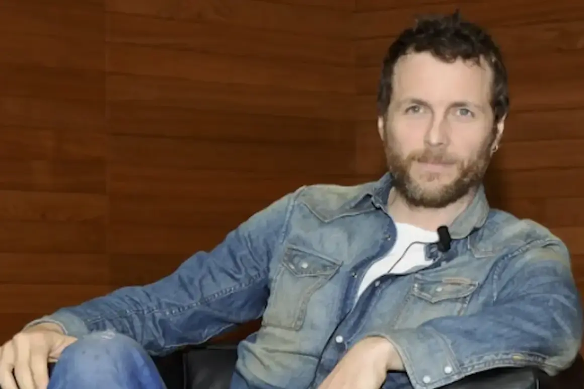 Jovanotti, con la sua camicia di jeans, sembra pronto a cantare "Mi fido di te".