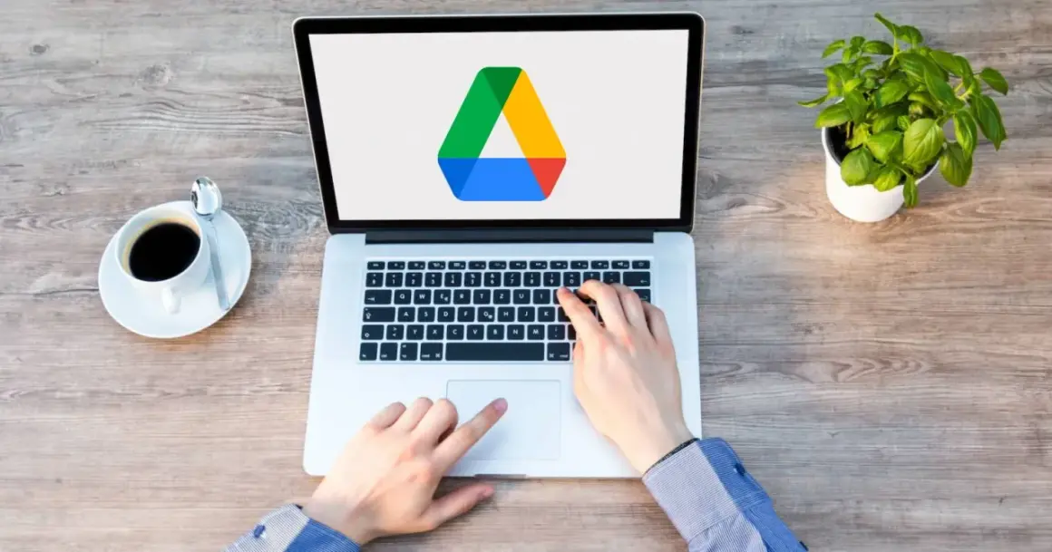 Frustrated hands try to access Google Drive on a laptop, but the screen shows only the logo, suggesting it's not loading.
