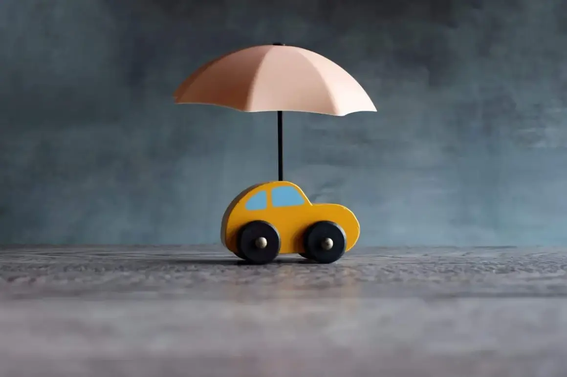 Voiture jaune sous parapluie, symbolisant une assurance courte durée.
