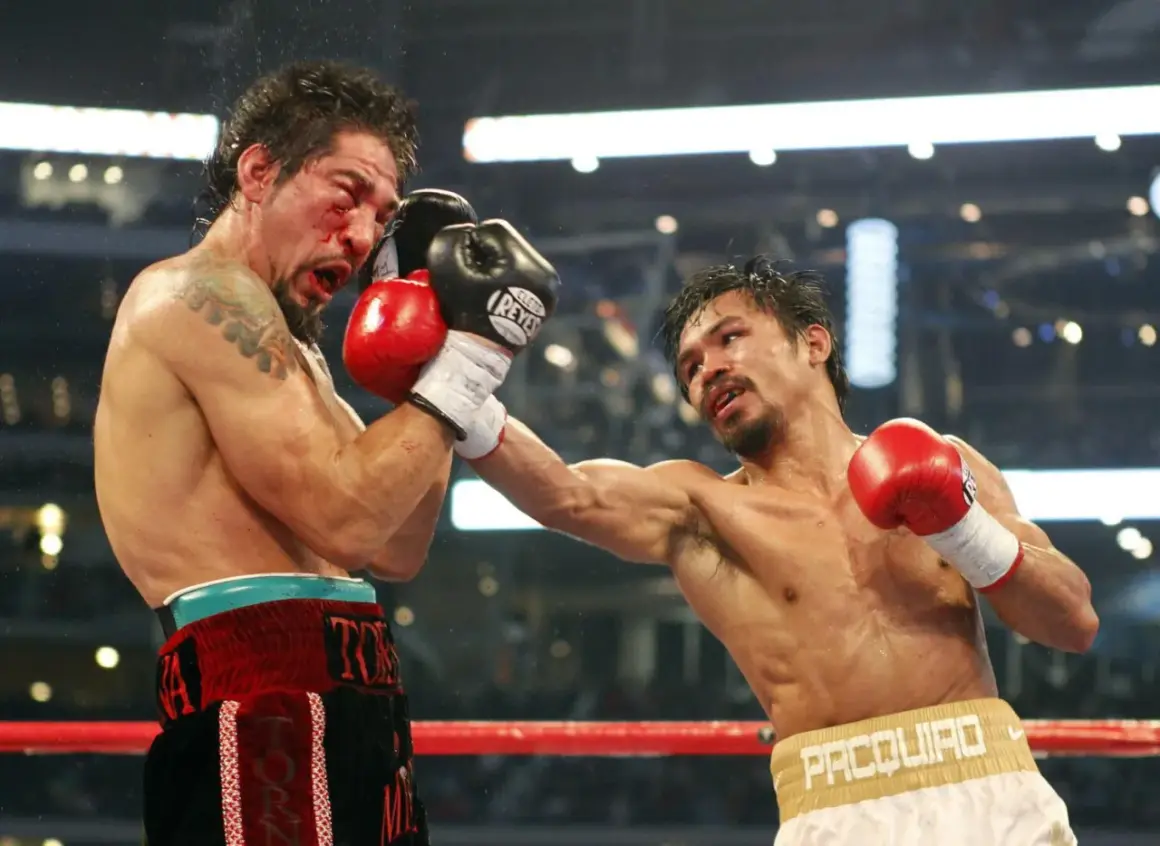 Intensiv boxning match där en boxare träffas hårt i ansiktet. Blod stänker och motståndaren levererar en kraftfull slag.