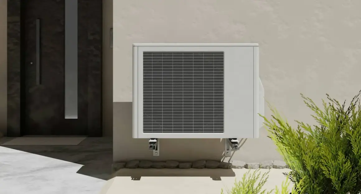 Unité extérieure de clim 2,5 kW, idéale pour une surface de 25 à 35 m². Installée près d'une porte d'entrée moderne.
