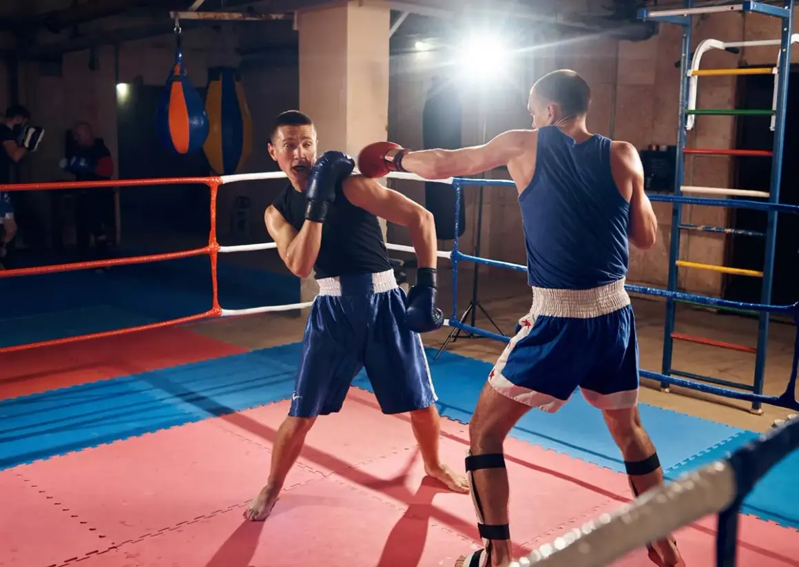Two boxers spar in a ring, demonstrating how to fight boxing with jabs and defensive moves.