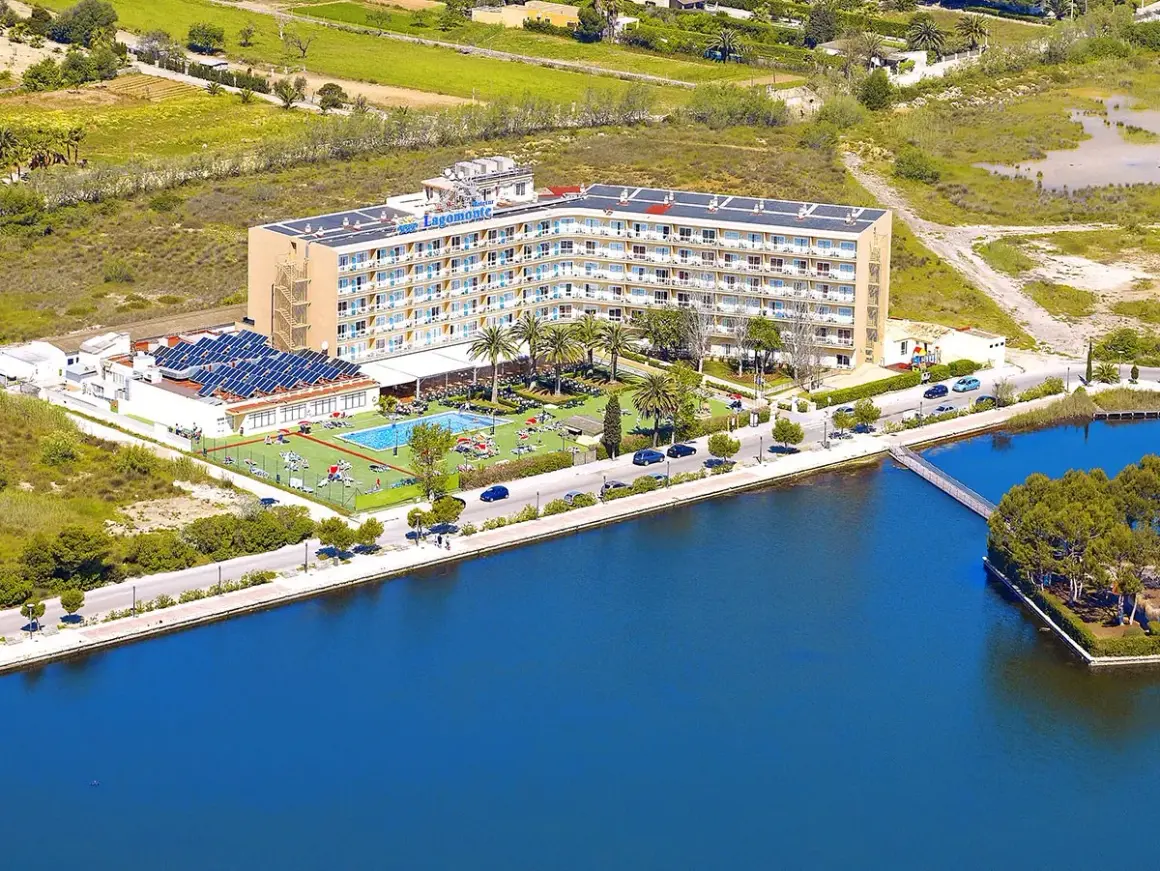 Hotel Tui Suneo Lagomonte z basenem i panelami słonecznymi, położony nad błękitną wodą.